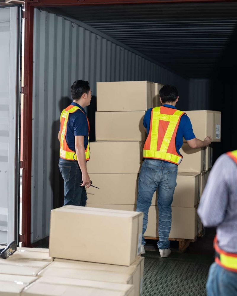 4 men Warehouse worker open doors steel 40 feet container and help carry box one by one supervisor stand near by using paper clip checklist